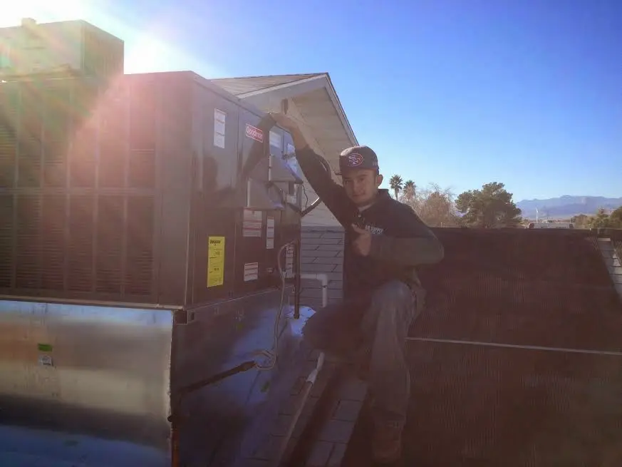 HVAC technician performing Heat Pump Repair on a rooftop unit in Ranchettes