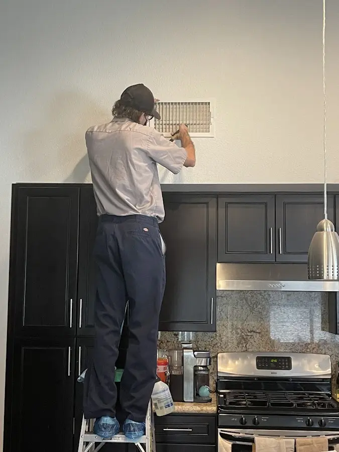 Technician inspecting an air vent during HVAC service in Ranchettes
